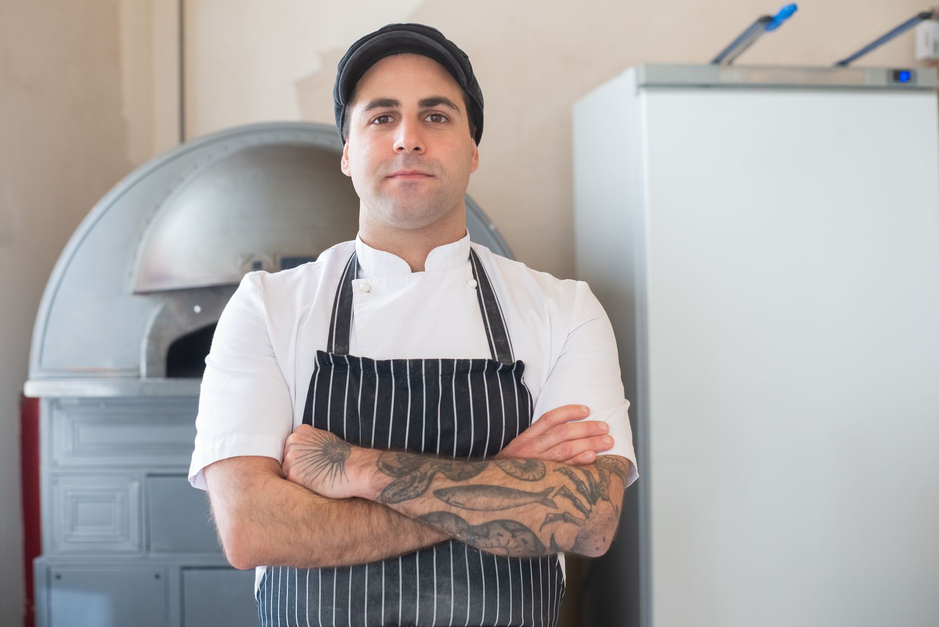 Chef standing beside a kitchen oven